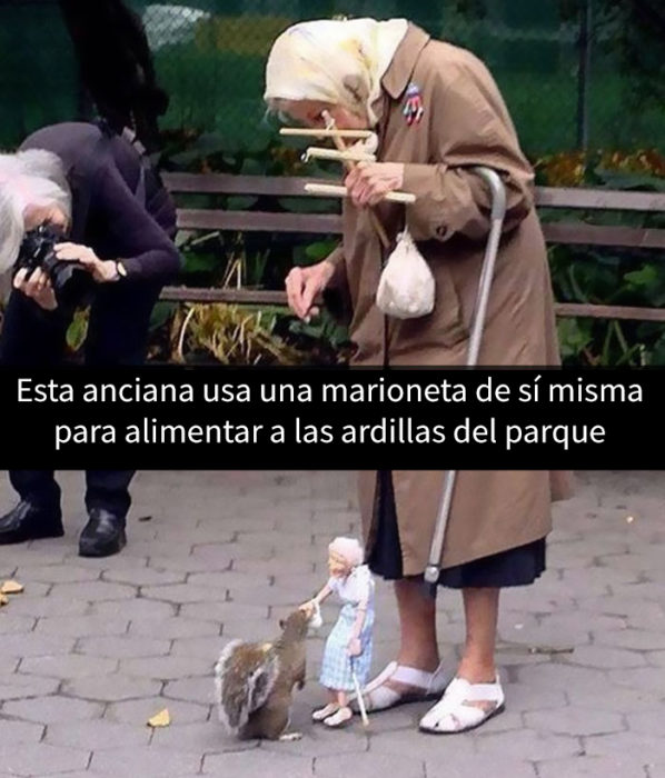 una anciana dando de comer a las ardillas con una marioneta de ella misma