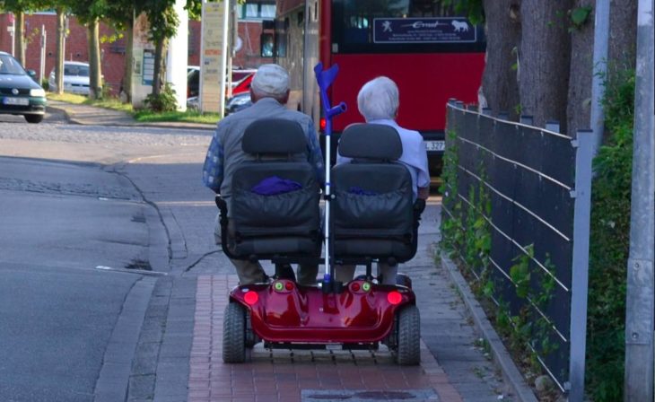 Pareja mayor paseando en sillas de rueda automáticas