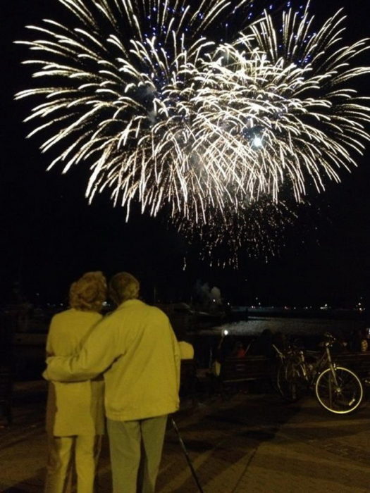 Pareja mayor abrazados viendo los fuegos artificiales