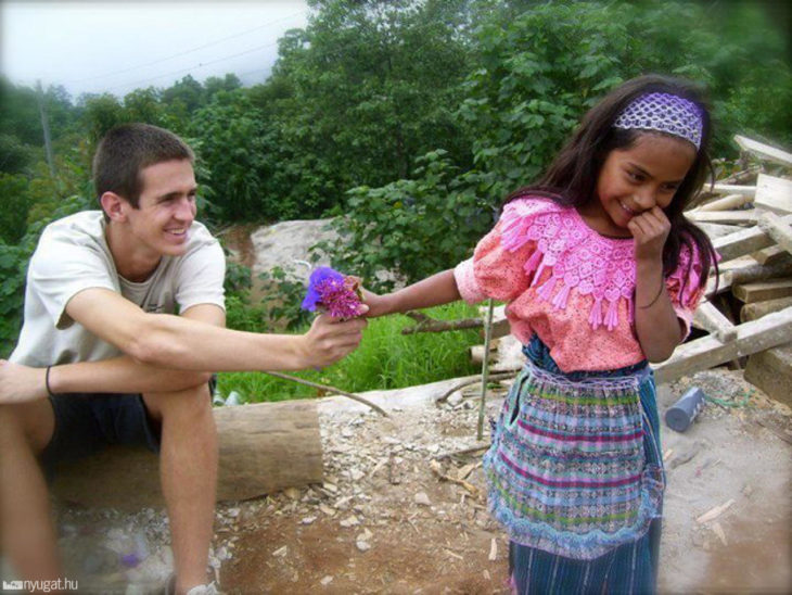 foto de turista que le da una flor a niña 