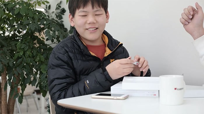 Niño asiático ciego tocando reloj