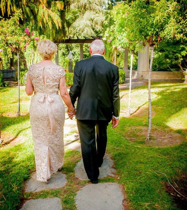 pareja de adultos mayores caminan por un jardín