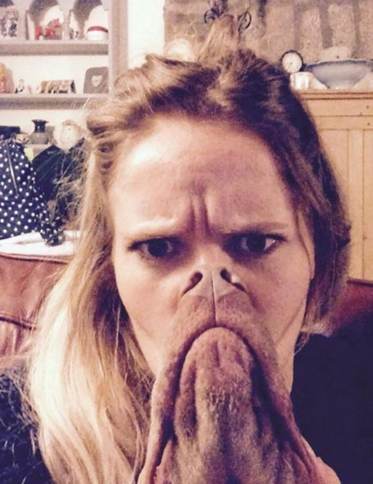 chica con un perro enfrente parece que tiene cara de perro