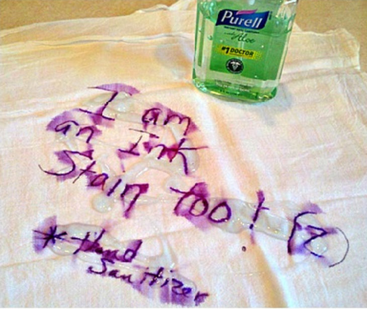 letras escritas en tinta púrpura sobre camisa blanca y gel antibacterial