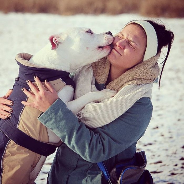 perro blanco besa a su dueña