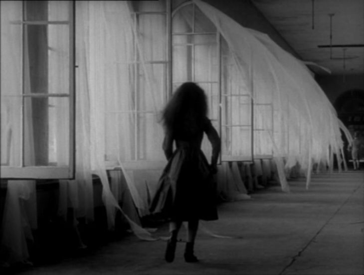 niña camina en un pasillo oscuro