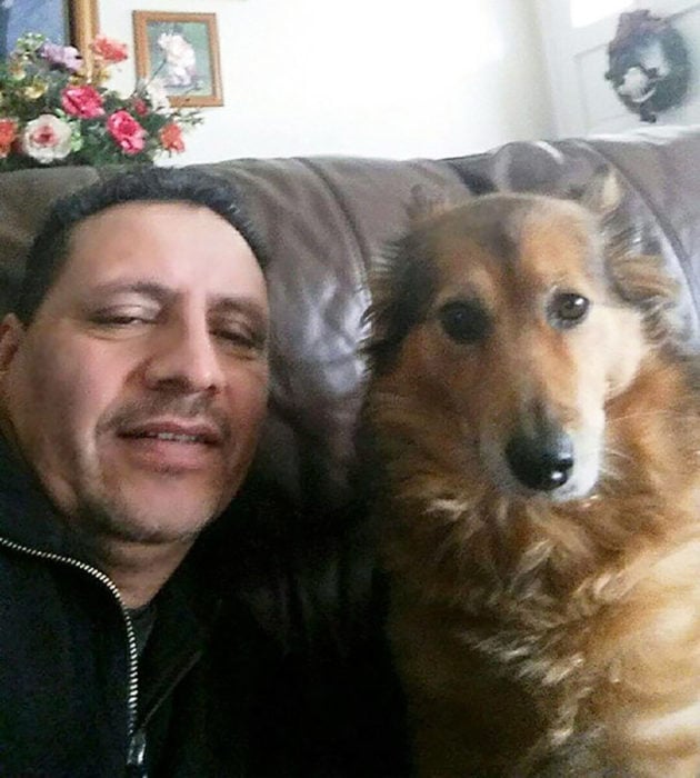 hombre sonriendo al lado de un perro