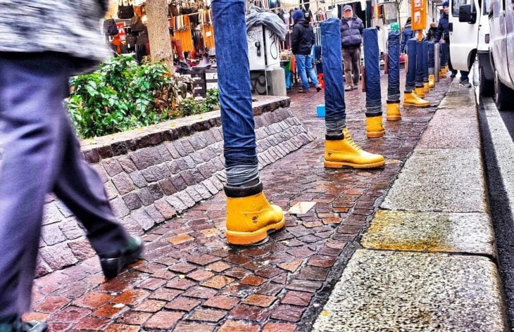 tubos con jeans y botas en una calle