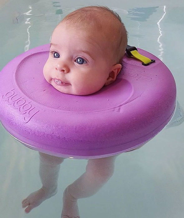 niña bebé nadando flotador rosa