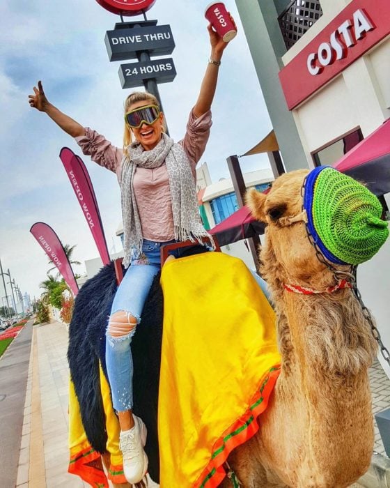 mujer montada en un camello en la ciudad