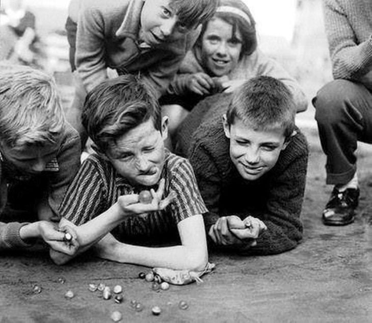 niño jugando a las canicas