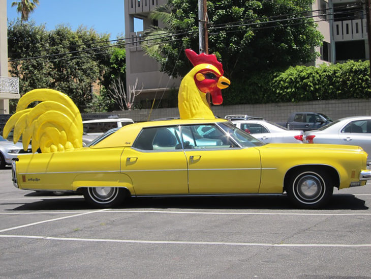 carro amarillo con cabeza y cola de pollo