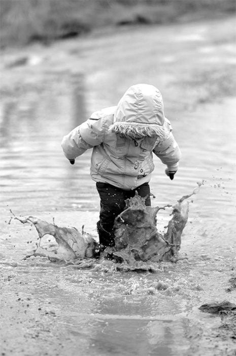 niño jugando en un charco