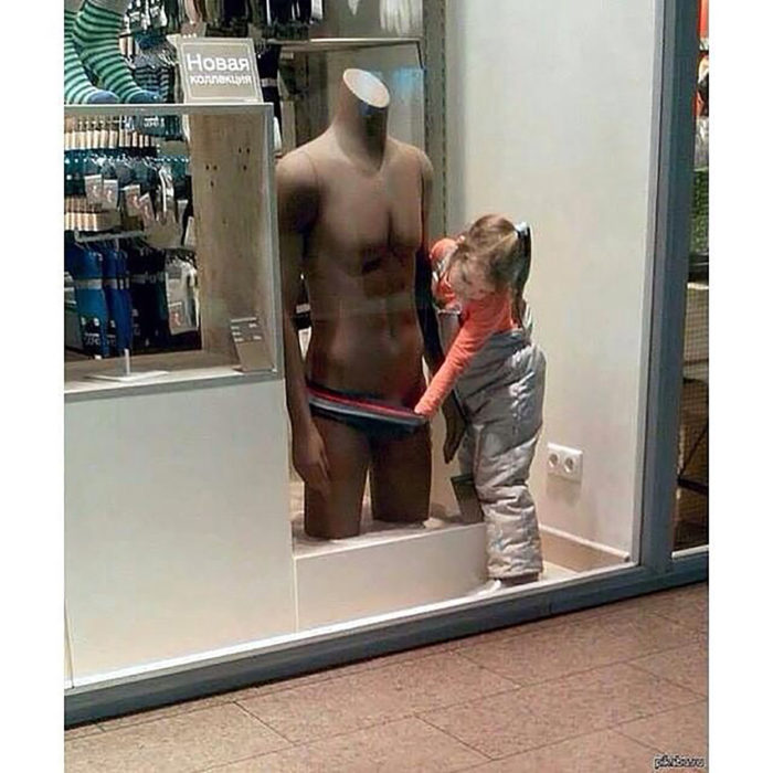 niña mirando los calzones de un maniquí 