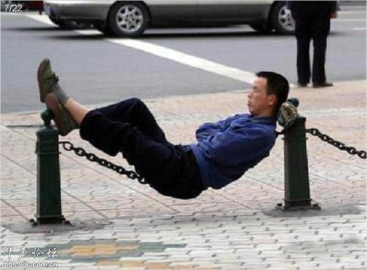 hombre recostado en cadenas en la calle