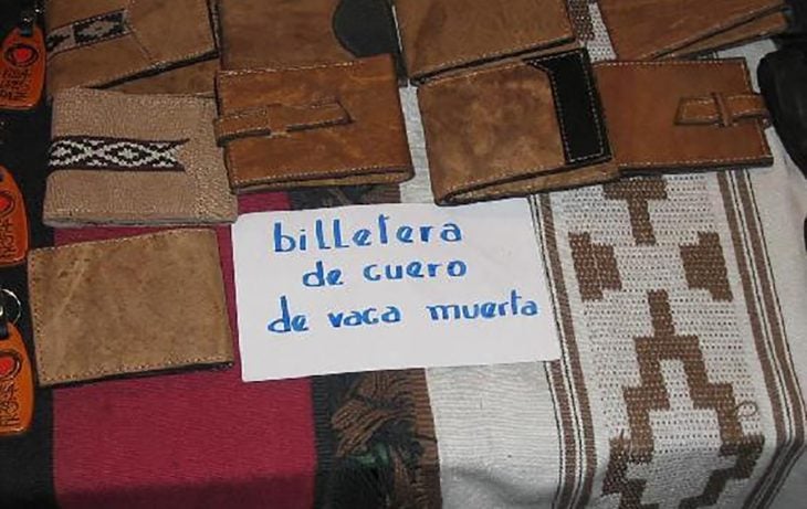 billeteras y un cartel que dice billetera de cuero de vaca muerta