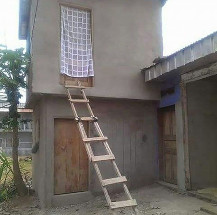 casa de dos pisos en obra negra y una escalera de madera