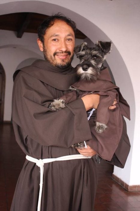 monje cargando a un perrito