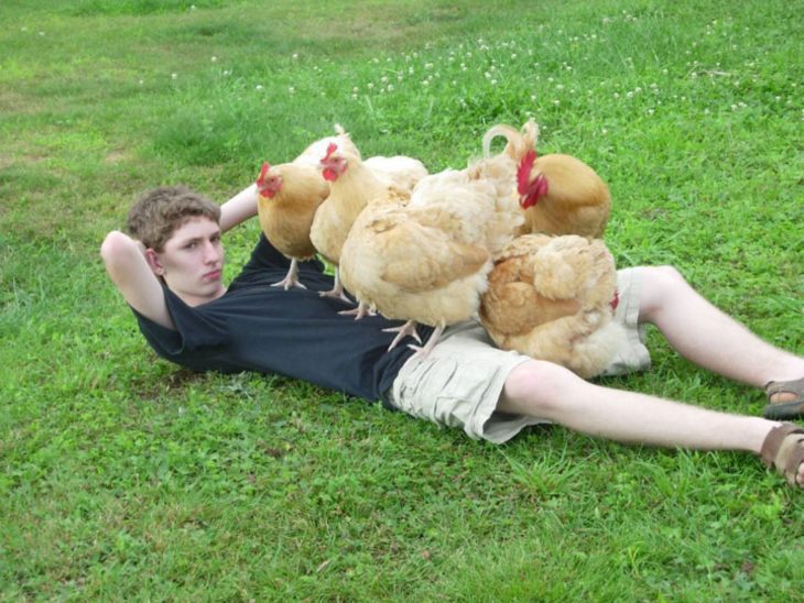 chico posando con gallinas