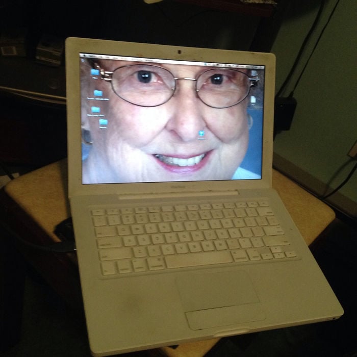 laptop con la foto de una anciana como fondo de pantalla