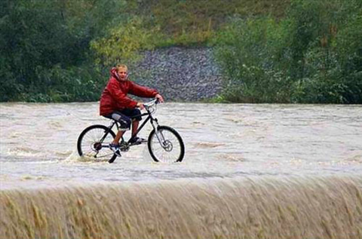 hombre manejando una bicicleta en una cascada
