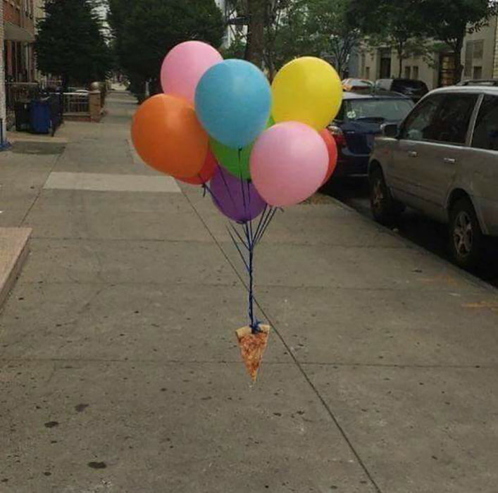 pizza atada a unos globos