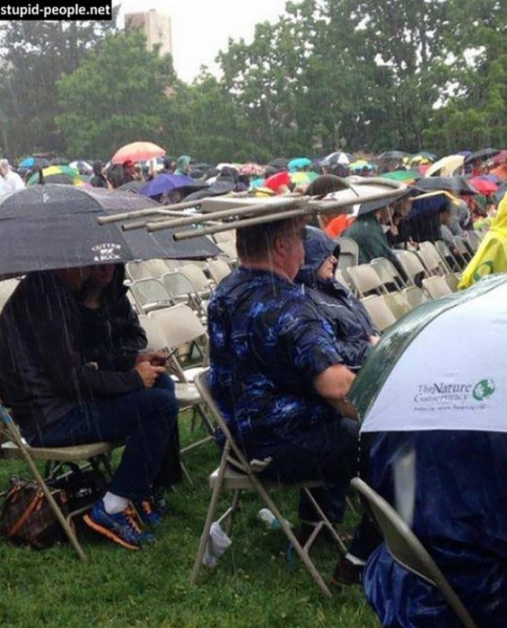 hombre utiliza una silla como paraguas