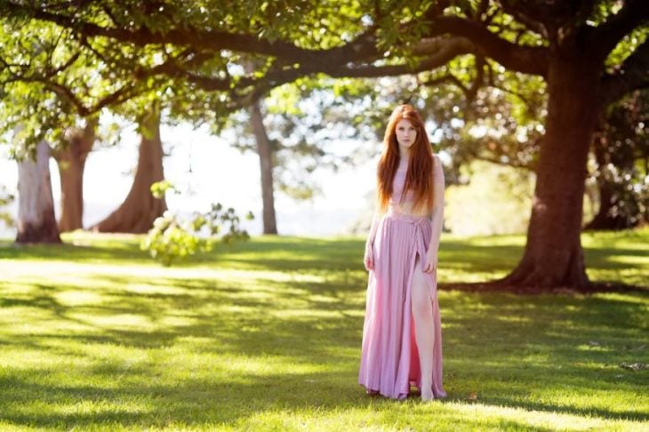 mujer pelirroja con vestido rojo en el campo 