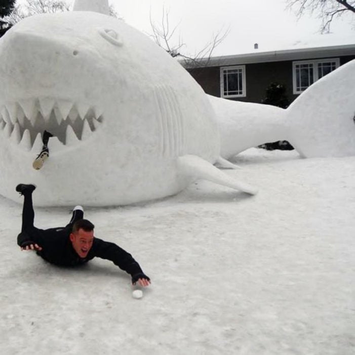 hombre sin pierna hace un tiburón con nieve y finge que le comió la pierna