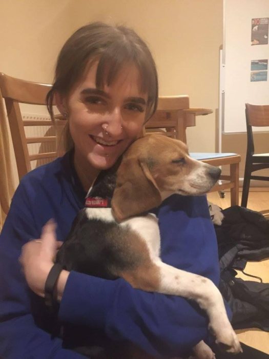 mujer abrazando a beagle mientras él duerme 