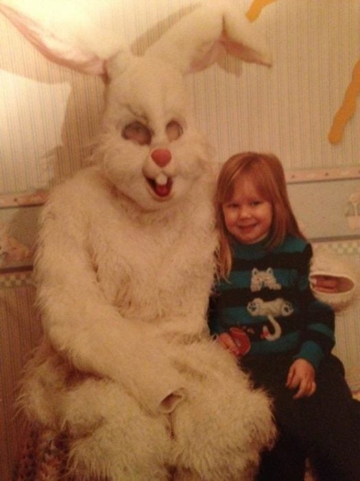 pequeña sonriendo junto al conejo de pascua terrorífico vintage