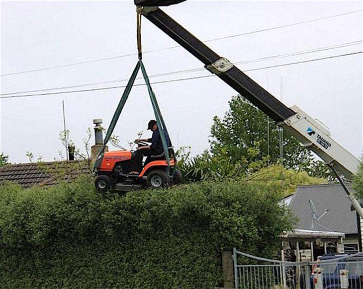 Hombre podando sostenido por una máquina 