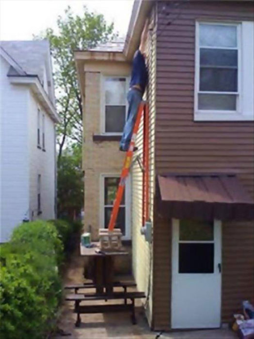 hombre pintando la casa la escalera sostenida en una mesa 