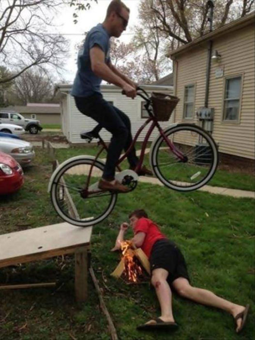 chico brincando en la bici sobre otro amigo 