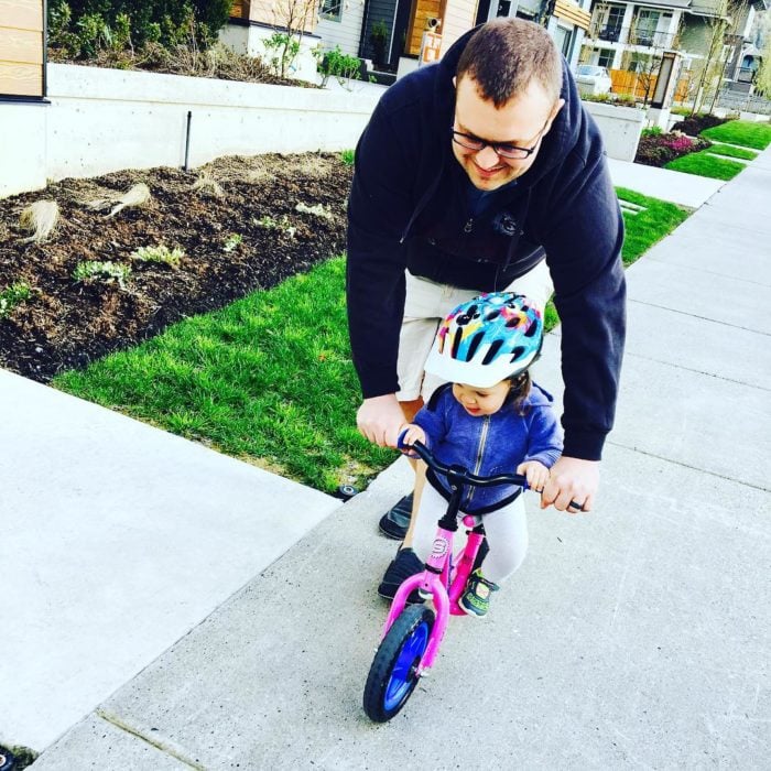 papá enseñando a su hija a andar en bici 