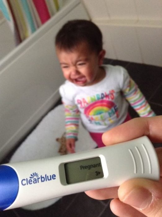 niño llora cuando su madre le muestra una prueba de embarazo