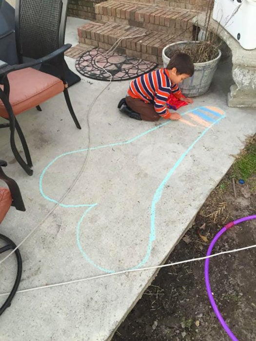 niño dibuja un corazón en el suelo que parece un símbolo fálico