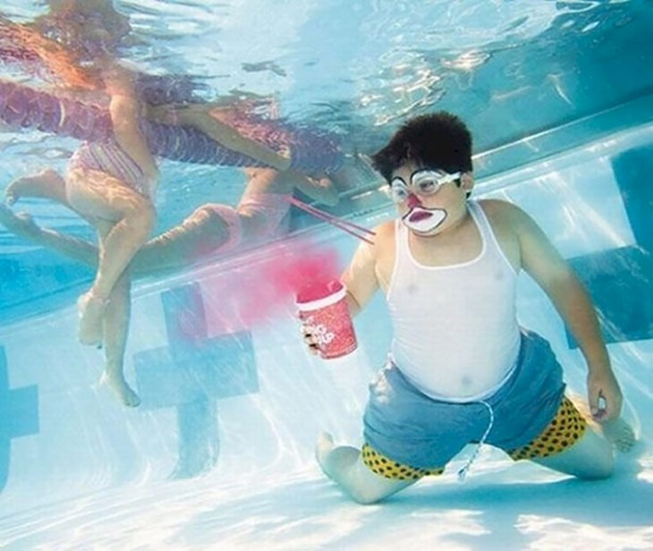 chico con un helado debajo de una piscina 