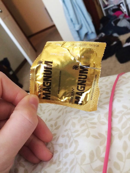 mano con un condón dorado
