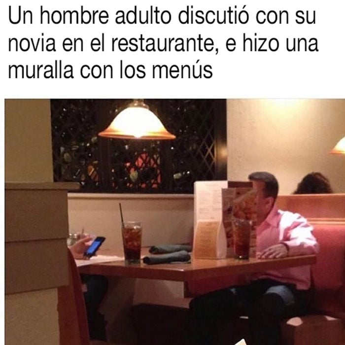 hombre hace un fuerte con los menús del restaurante