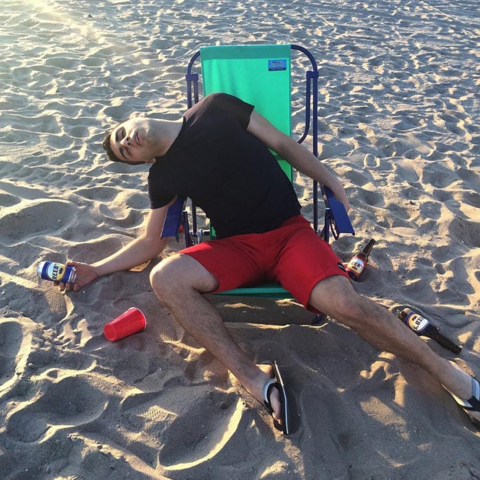 borracho sentado en la playa