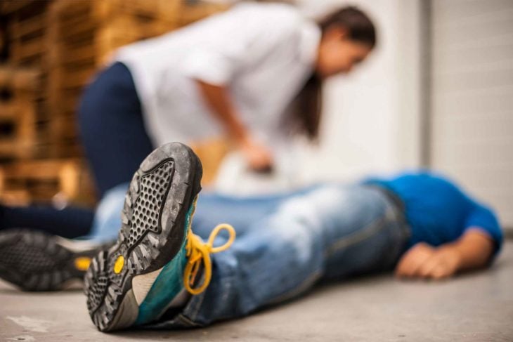 persona atendiendo a un hombre que se desmayó 