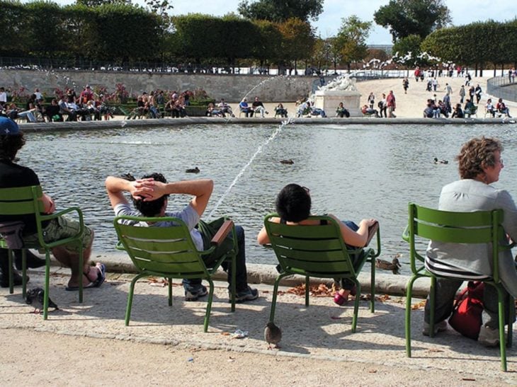 hombre sentado frente a un lago y una fuente parece su orina 