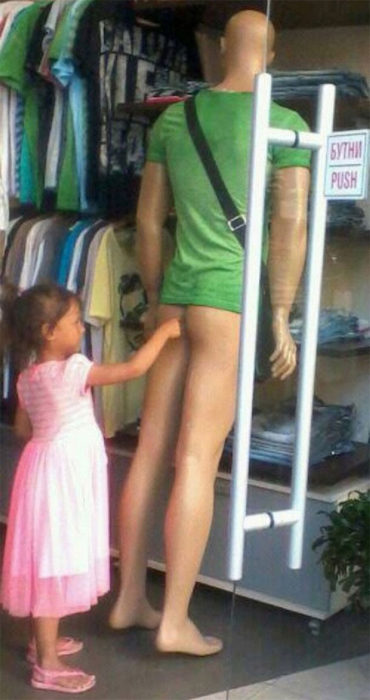 niña toca el trasero de un maniquí masculino