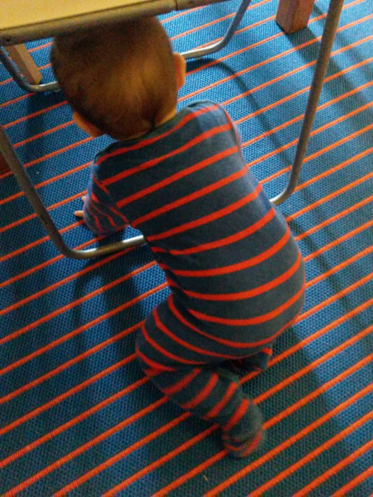 bebé vestido a rayas se camufla con el piso