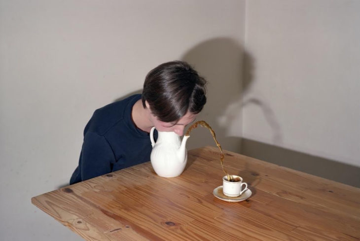 mujer sopla una tetera y el líquido cae en una taza