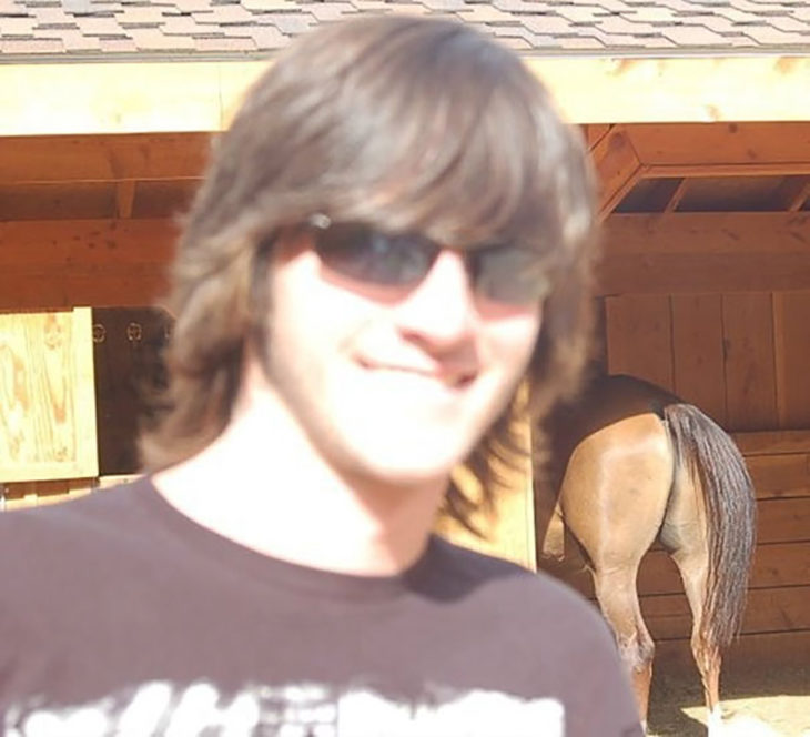 muchacho se toma foto en un establo y la cámara decide enfocar el trasero del caballo