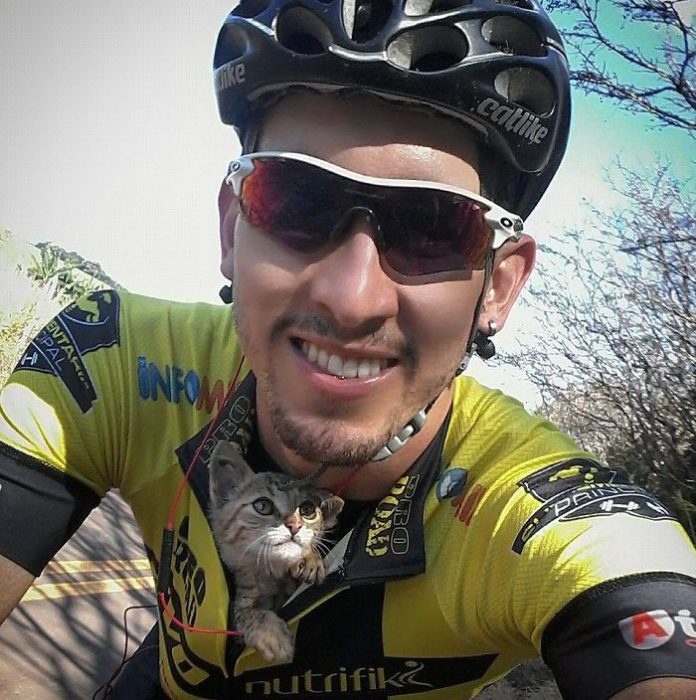 Ciclista con gatito bebé dentro de su playera