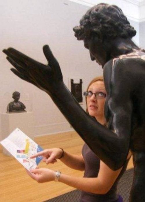 Mujer pidiendo instrucciones a una estatua 