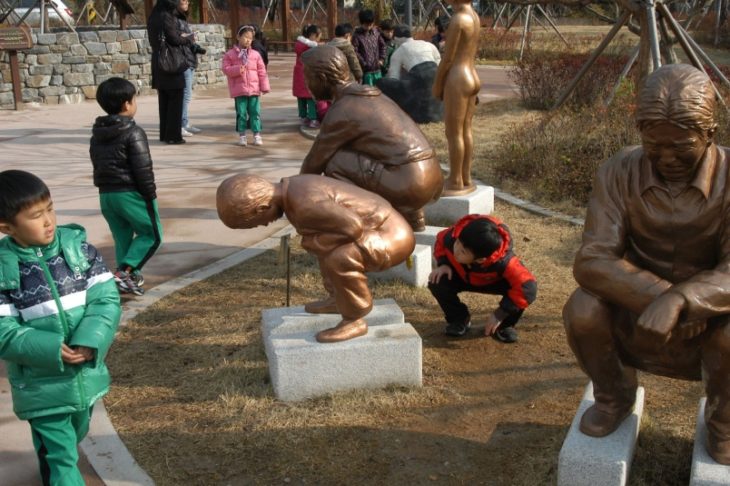 Niño asomándose en estatua 